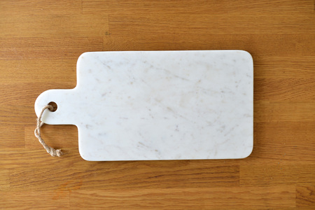 White marble cheese board in a kitchen with cheese and grapesの写真素材