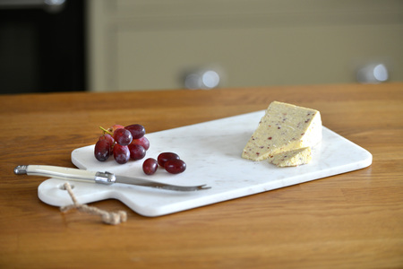 White marble cheese board in a kitchen with cheese and grapesの写真素材