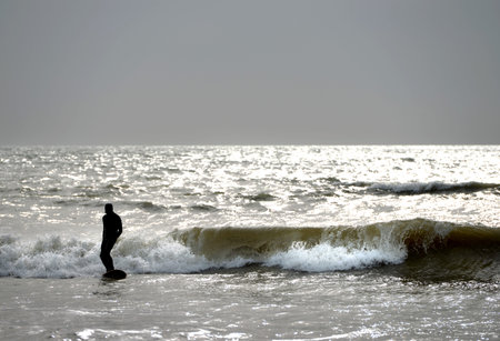 Surfer surfing during a grey winter day in britain