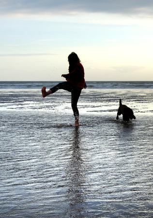 Young girl playing in the water on a sandy beachの写真素材