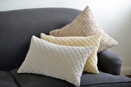 Selection of different cushions on a grey couchの写真素材