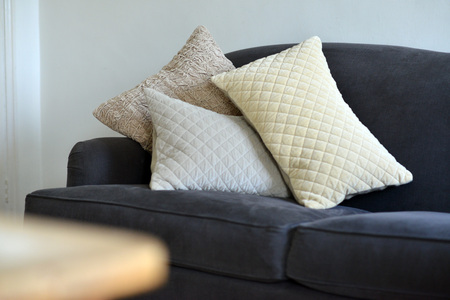 Selection of different cushions on a grey couchの写真素材