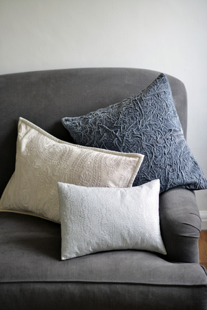 Selection of different cushions on a grey couchの写真素材