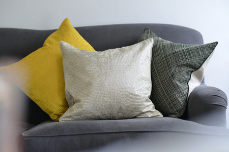 Selection of different cushions on a grey couchの写真素材
