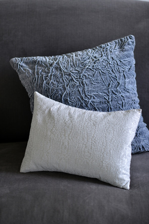 Selection of different cushions on a grey couchの写真素材