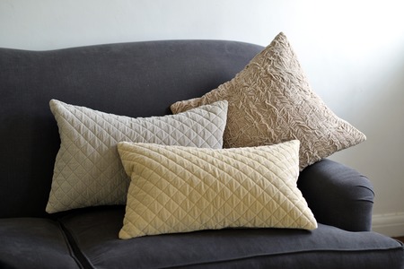 Selection of different cushions on a grey couchの写真素材