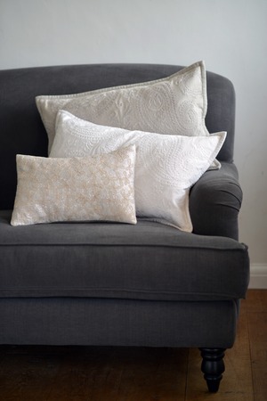 three textured stylish cushions on a grey sofaの写真素材