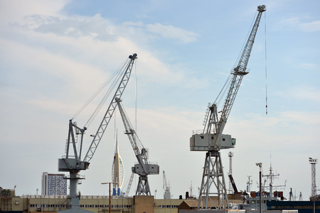 Three grey shipping cranes in a dockyardの写真素材