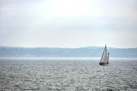 Yacht sailing on a grey overcast day near Portsmouth, UKの写真素材