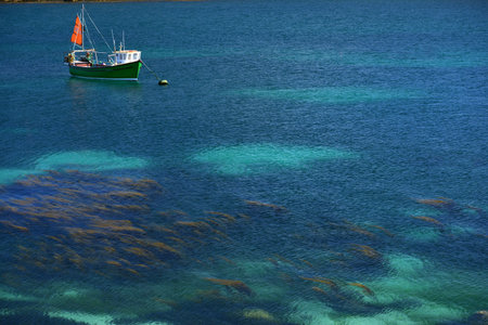 Small fishing boat in a shallow azure sea