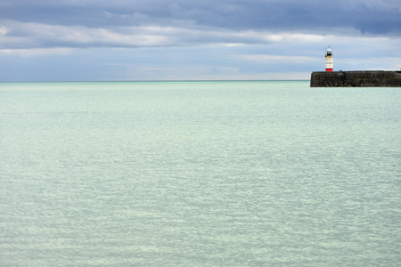 Pale sea surrounding Newhaven breakwater and lighthouse