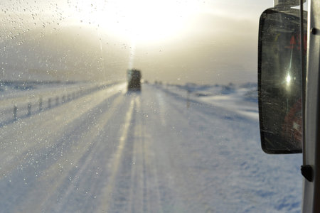 Snow and ice covered road in Iceland trough a windscreenの写真素材
