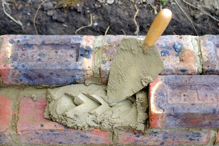 Bricklayers trowel and mortar on a construction siteの写真素材