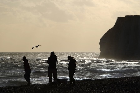 People with a dog on a stormy beachの写真素材