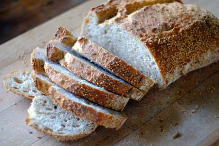 Freshly sliced artisan bread on a wooden board.の写真素材