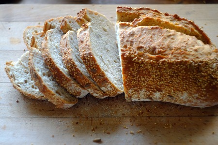 Freshly sliced artisan bread on a wooden board.の写真素材