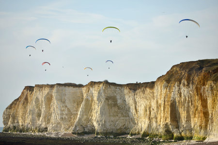 Paragliders over chalk sea cliffs in Newhaven, East Sussex, UKの写真素材