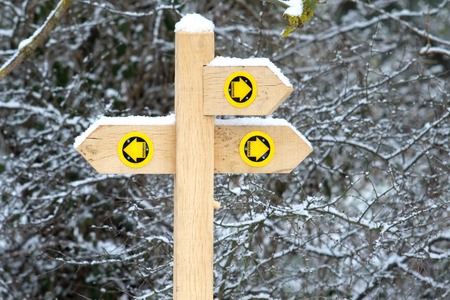 Three way footpath signpost covered in snowの写真素材