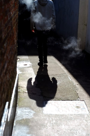 Figure in a misty and dark alley in Lewes, UK