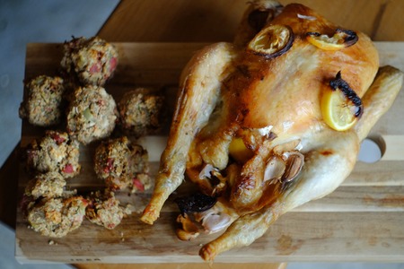 Roast chicken and stuffing on a chopping boardの写真素材