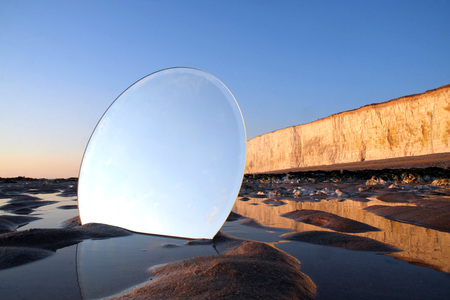 Round mirror on a beach at sunset.の写真素材