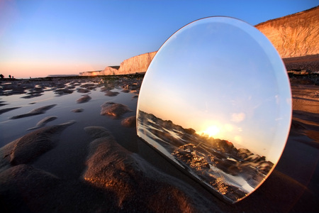 Round mirror on a beach at sunset.の写真素材