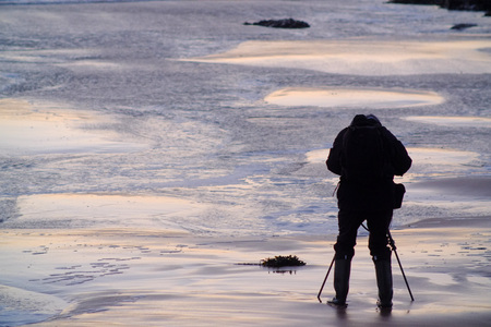 Silhouette of a photographer on a beach at sunsetの写真素材