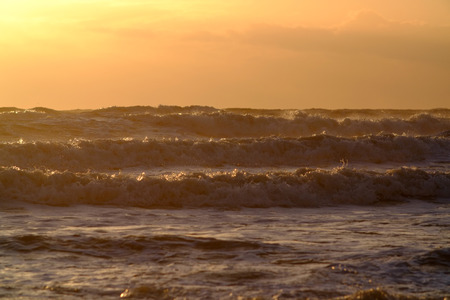 Rough seas and waves at sun setの写真素材