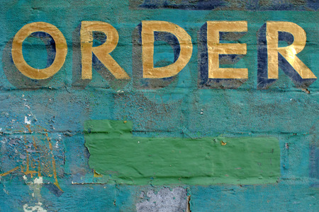 Gold leaf sign - order - on painted brick background.の写真素材