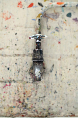 Paint spattered tap in an artists studioの写真素材
