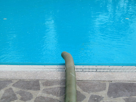Pouring fresh water into an outdoor swimmingpool to feed it up