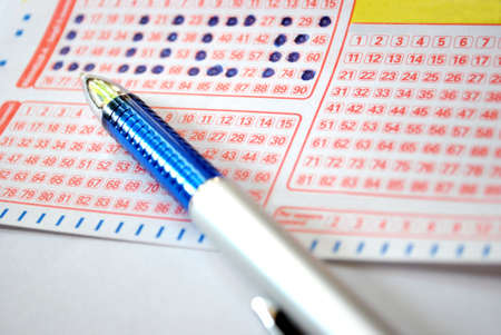 Closeup detail of a lottery ticket and a pen writing lucky wordの写真素材