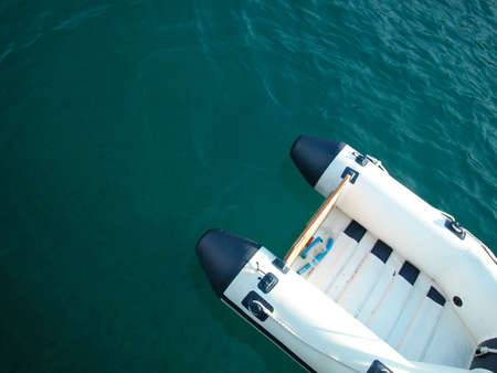 Aerial view of a rubber dinghy on deep blue waterの写真素材