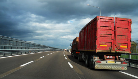 Red truck on highway under cloudy skyの写真素材