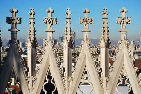 Duomo gothic cathedral of Milan, spires decoration detail, panorama in background, Lombardy, Italyの写真素材