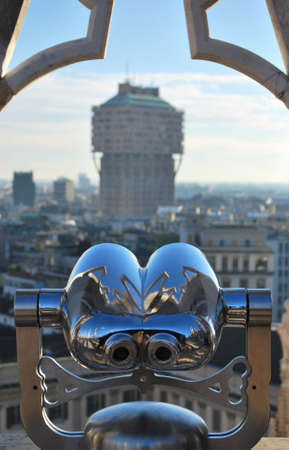 Binoculars telescope looking Milan panorama and Velasca Tower from the roof of the Duomo cathedral, Lombardy, Italyの写真素材
