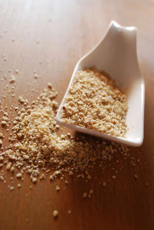 Gomasio in white ceramic container on natural wooden table backgroundの写真素材