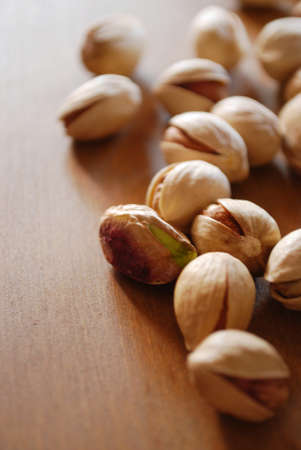 Roasted pistachios on natural wooden table backgroundの写真素材