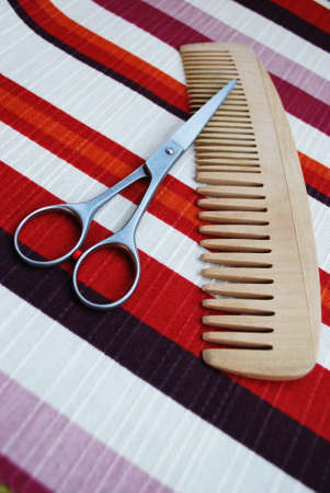 Professional scissors and wooden comb on colorful backgroundの写真素材