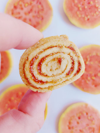 Close up of a woman's hand holding a piece of guava cakeの写真素材