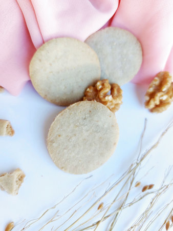 cookies with nuts on a pink napkin on a white backgroundの写真素材