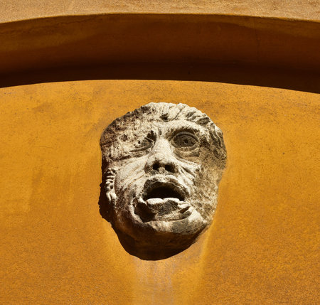 Relief of an ancient grotesque face or mask on a wall in Venice