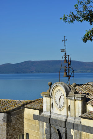 Lake Bracciano viewed from Anguillara Sabazia medieval walls with ancient clockの写真素材