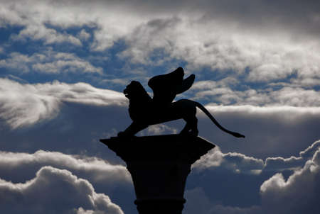 Saint Mark Winged Lion old medieval statue silhouette among cloudsの写真素材