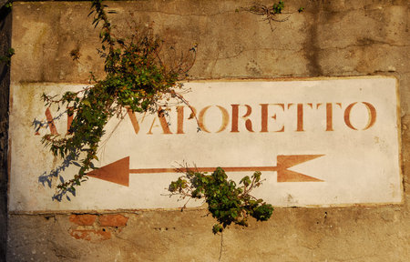'Vaporetto' (venetian water bus) old road sign with plants on a wall in Venice