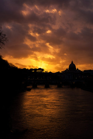 Beautiful sunset over River Tiber in Rome historic center with St Peter domeの写真素材