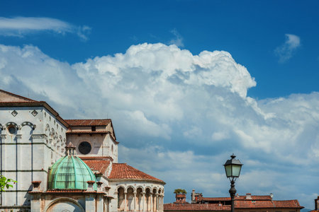 Beautiful clouds above Lucca historic center with cathedral apse and Guinigi medieval tower (with copy space)の写真素材