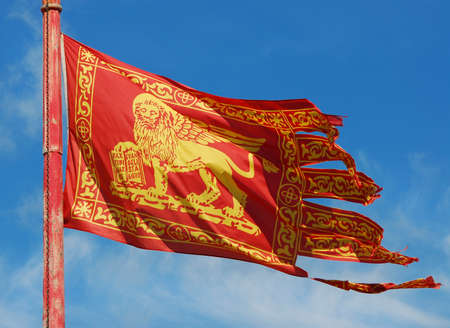 Old Venice Republic Flag with Saint Mark Lion fluttering in the windの写真素材