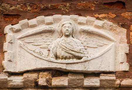 Ancient stone relief of an angel on a Venice wallの写真素材