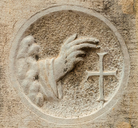 Blessing hand with cross, an ancient religious relief on a Venice wallの写真素材